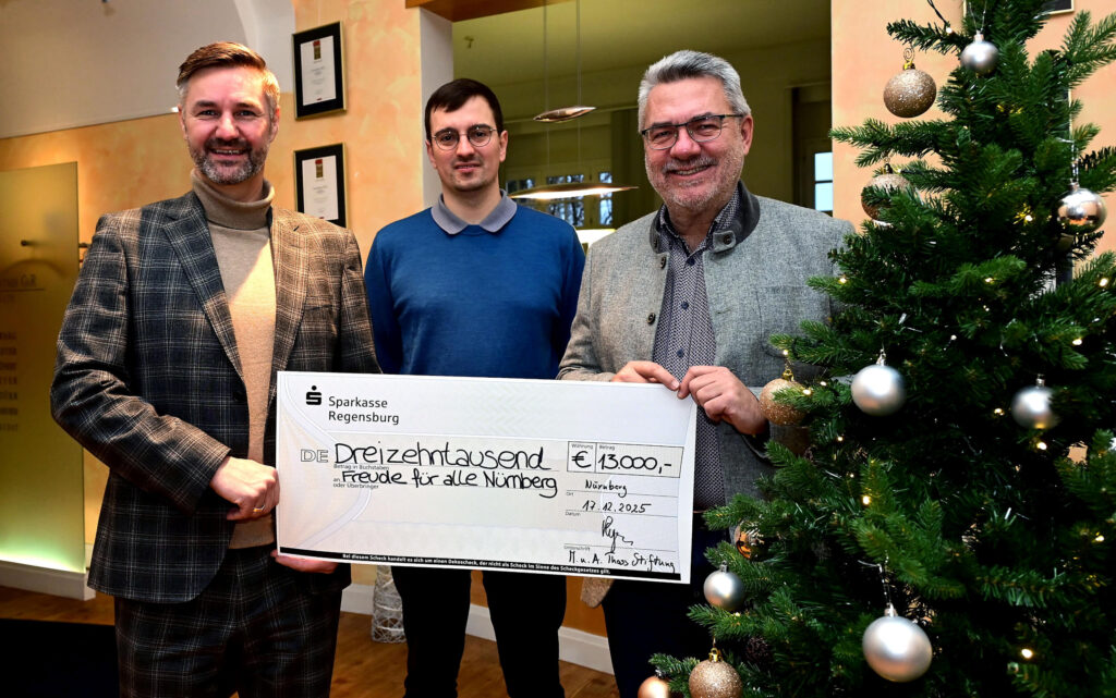 Theo Pleyer (erster Vorsitzender der Manfred-und-Anita-Thoß-Stiftung, rechts) und Alexander Grünert (Vorstandsmitglied, links) haben einen symbolischen Spendenscheck in Höhe von 13.000 Euro an Max Söllner (Mitte) übergeben, den für „Freude für alle“ verantwortlichen Redakteur.